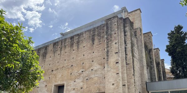Fachada hist&oacute;rica de ladrillo de la Sala Orive en C&oacute;rdoba, mostrando los mechinales y la estructura inacabada del siglo XVI.